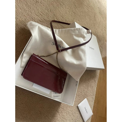 Petit sac SL Kate porté à l’épaule en cuir verni